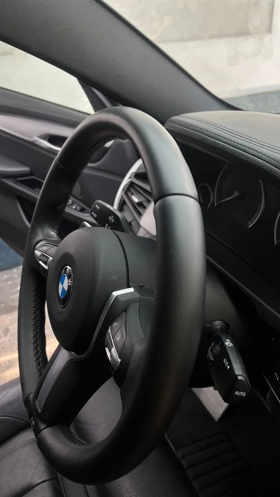 Habitacle BMW X6 après detailing auto intérieur à Clermont Créans — cuir et volant M Sport remis au standard.